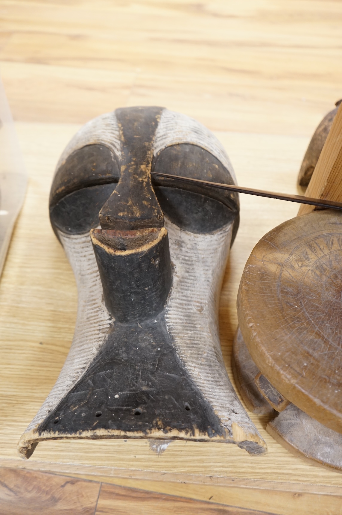 An eclectic group of tribal carvings to include a stool, various weapons, masks, etc, largest mask 52cm high